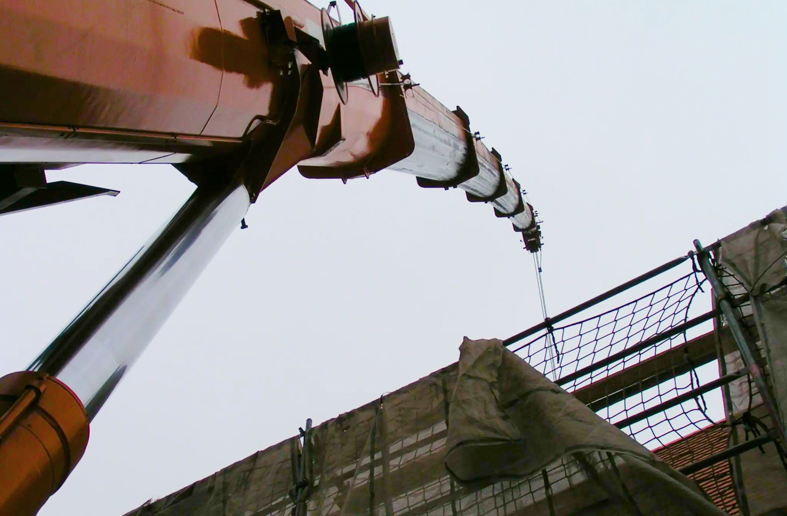 Froschperspektive eines großen Krans auf einer Baustelle