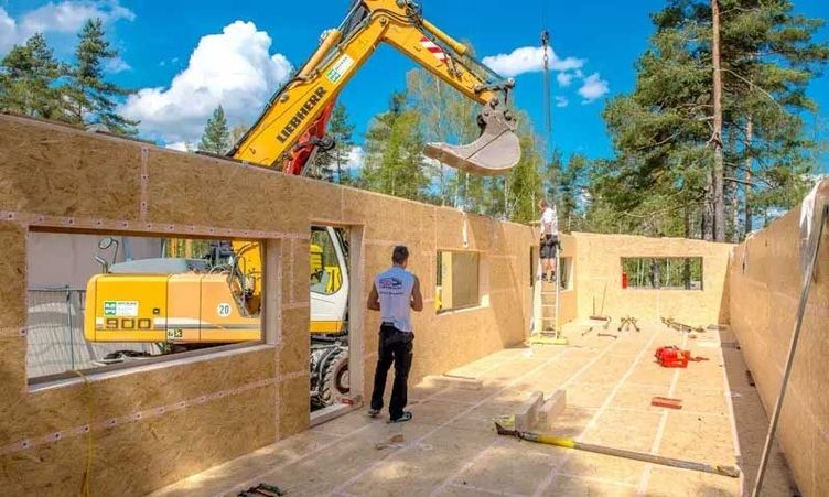 Zimmerer in einem Rohbau aus Holz